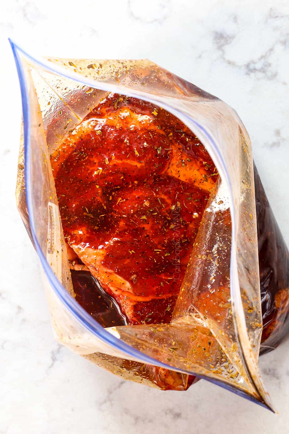 showing how to make steak marinade by adding the steak to the marinade and turning to coat