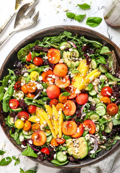 top view of summer salad with cherries, peaches, mangos, avocado and tomatoes