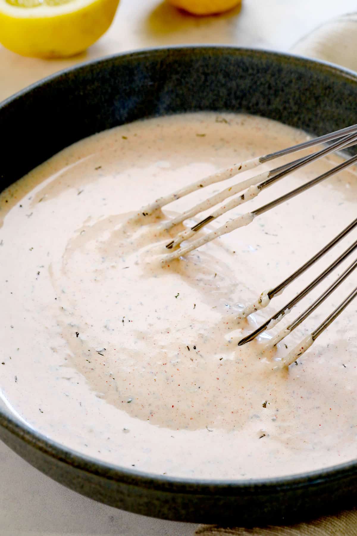 showing how to make Mediterranean salad by whisking the Greek salad dressing ingredients together