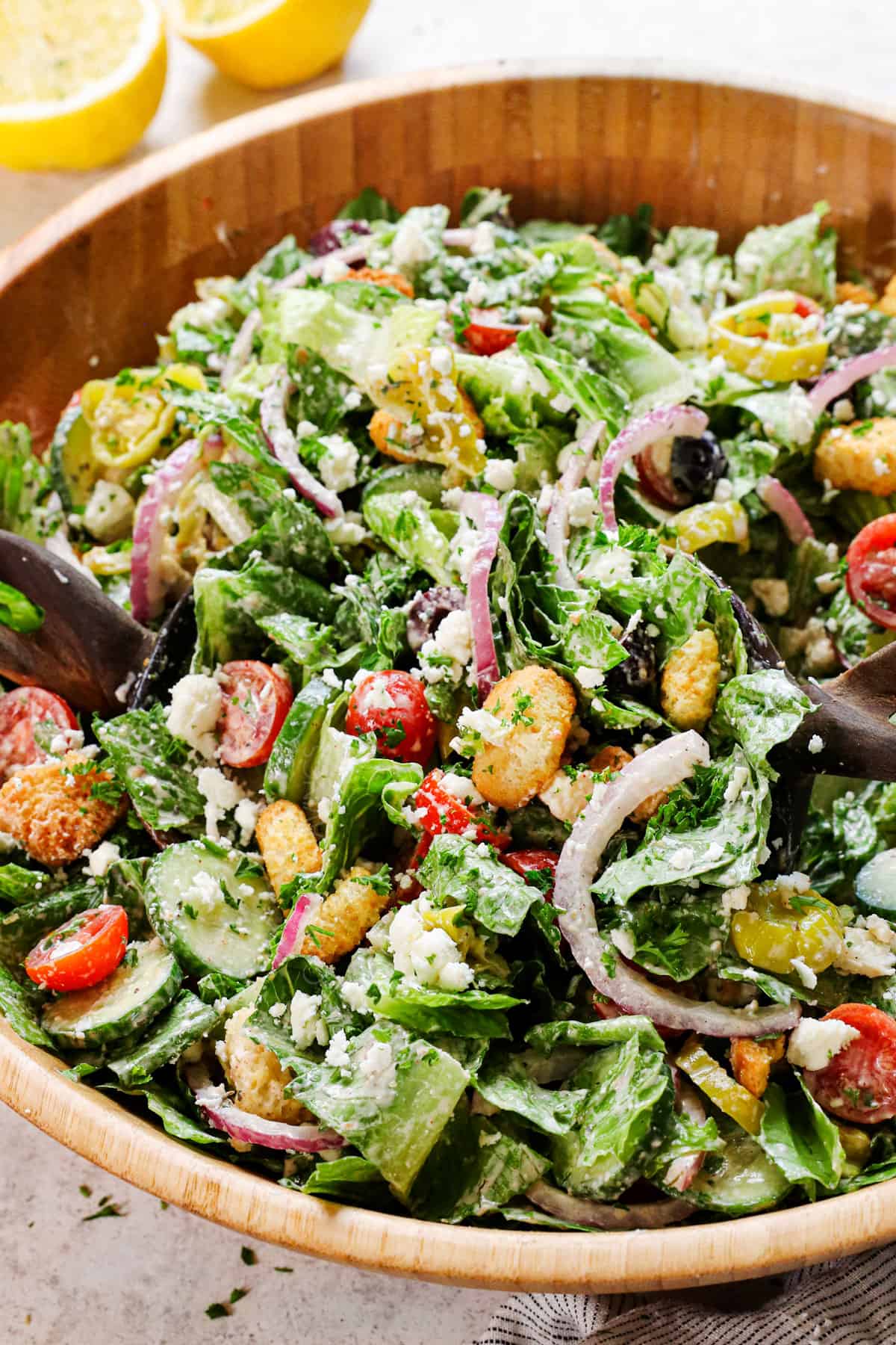 tossing Mediterranean salad recipe together in a bowl 