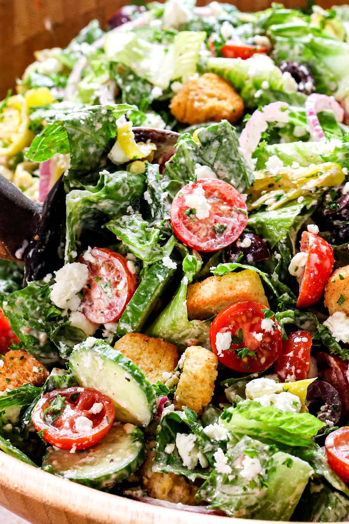 up close of showing how to make Mediterranean chopped salad showing the ingredients tossed together