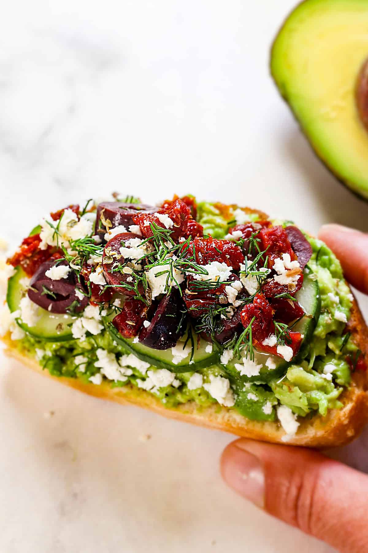 showing an avocado toast recipe variation inspired by Mediterranean flavors