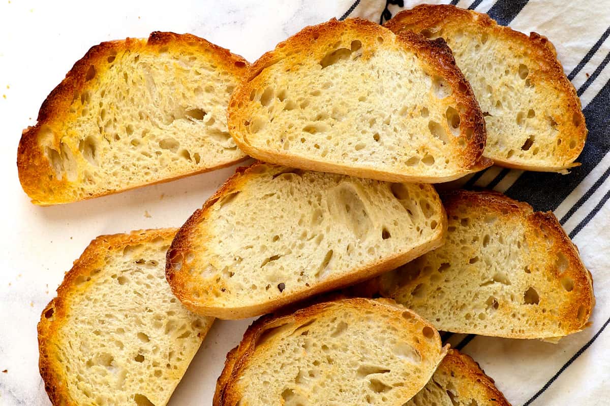 showing how to make avocado toast by toasting the bread until golden and crispy