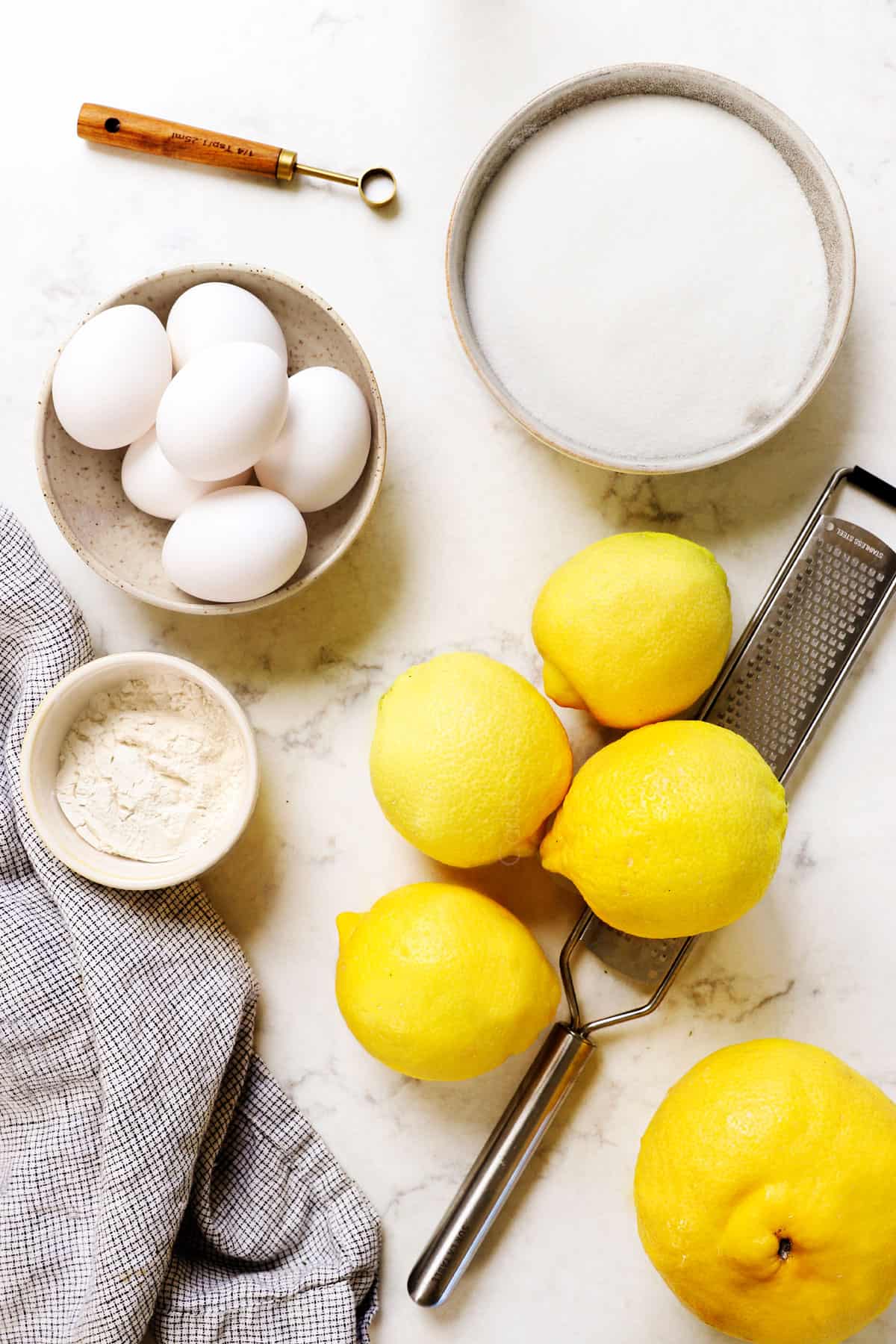 showing the ingredients for lemon bars recipe:  eggs, sugar, flour and lemons