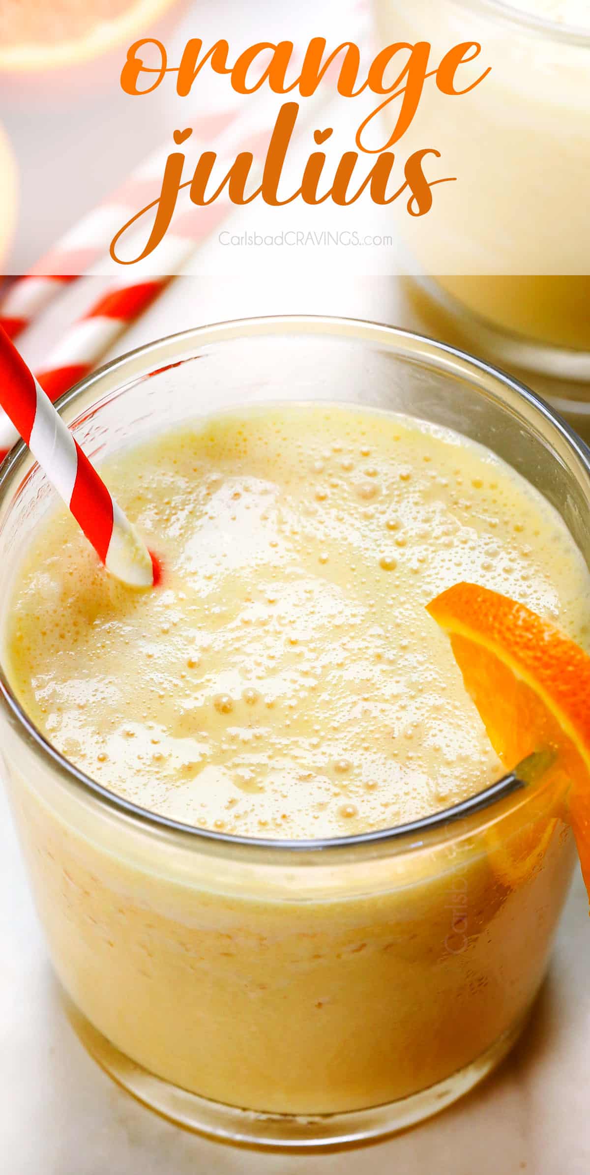 up close of orange Julius served in a glass with an orange and white striped straw