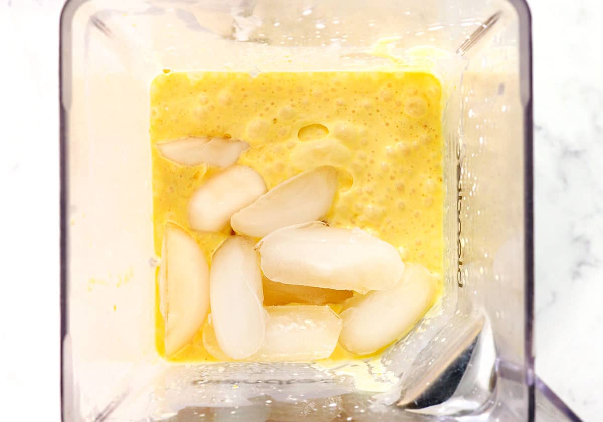 showing how to make orange Julius by adding ice cubes to the blender 