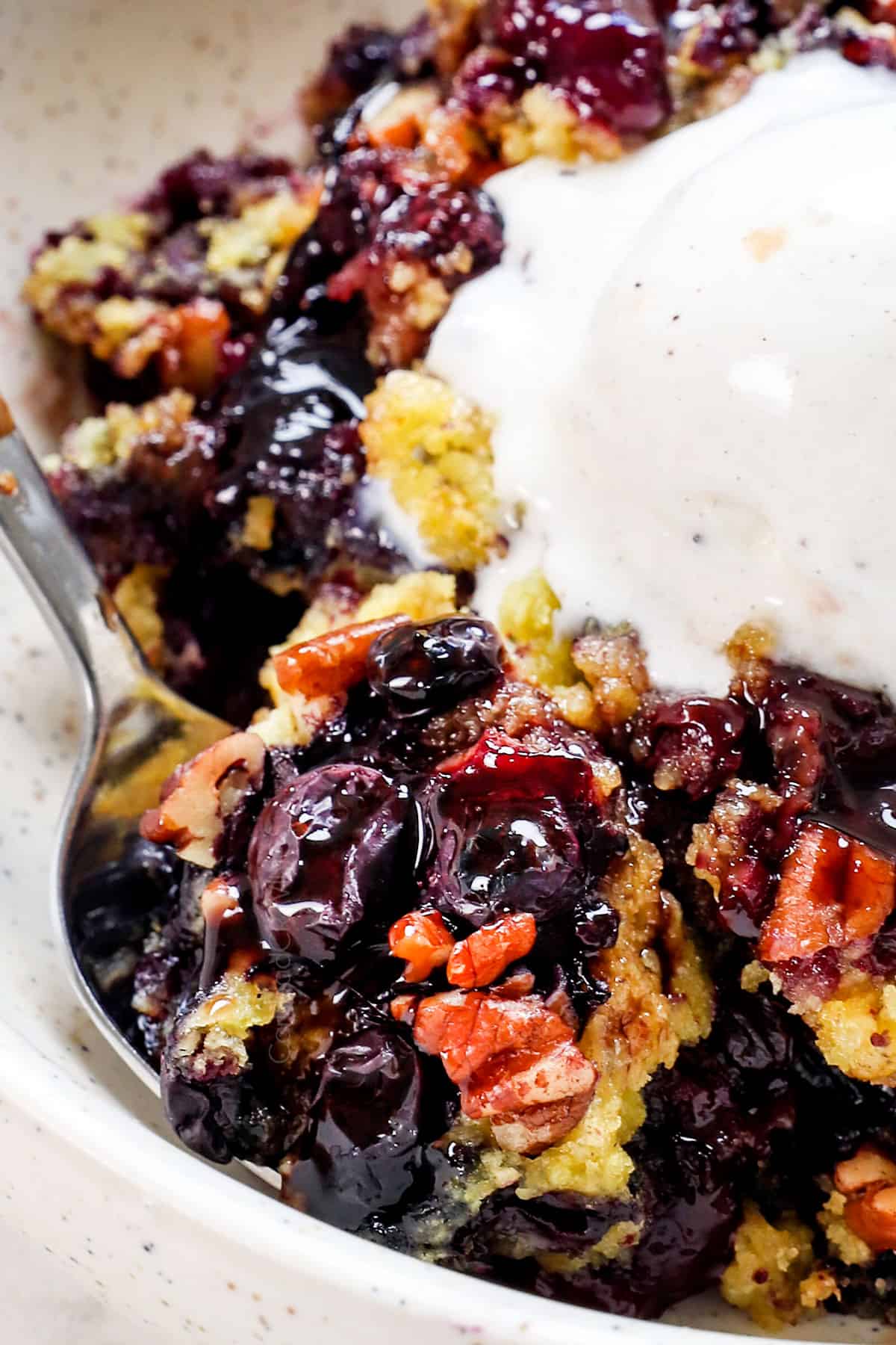 up close of a serving of blueberry dump cake showing how juicy the filling is