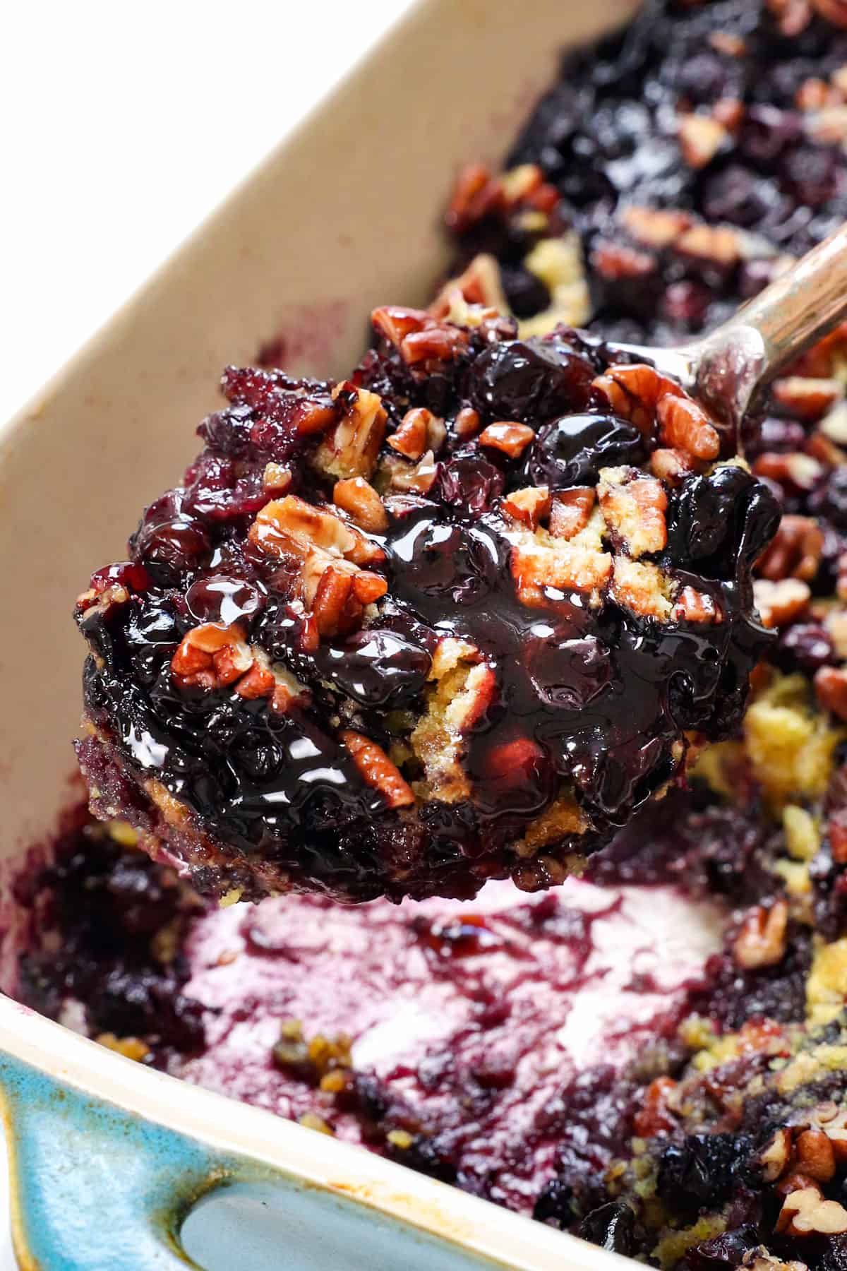 up close of a serving scoop of blueberry dump cake recipe showing how juicy the berries are