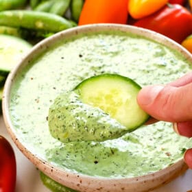 showing how to use green goddess dressing by dipping vegetables in it