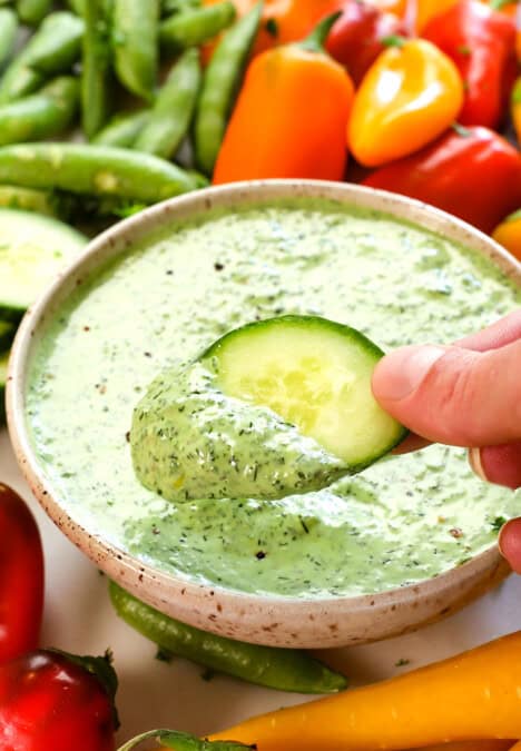 showing how to use green goddess dressing by dipping vegetables in it