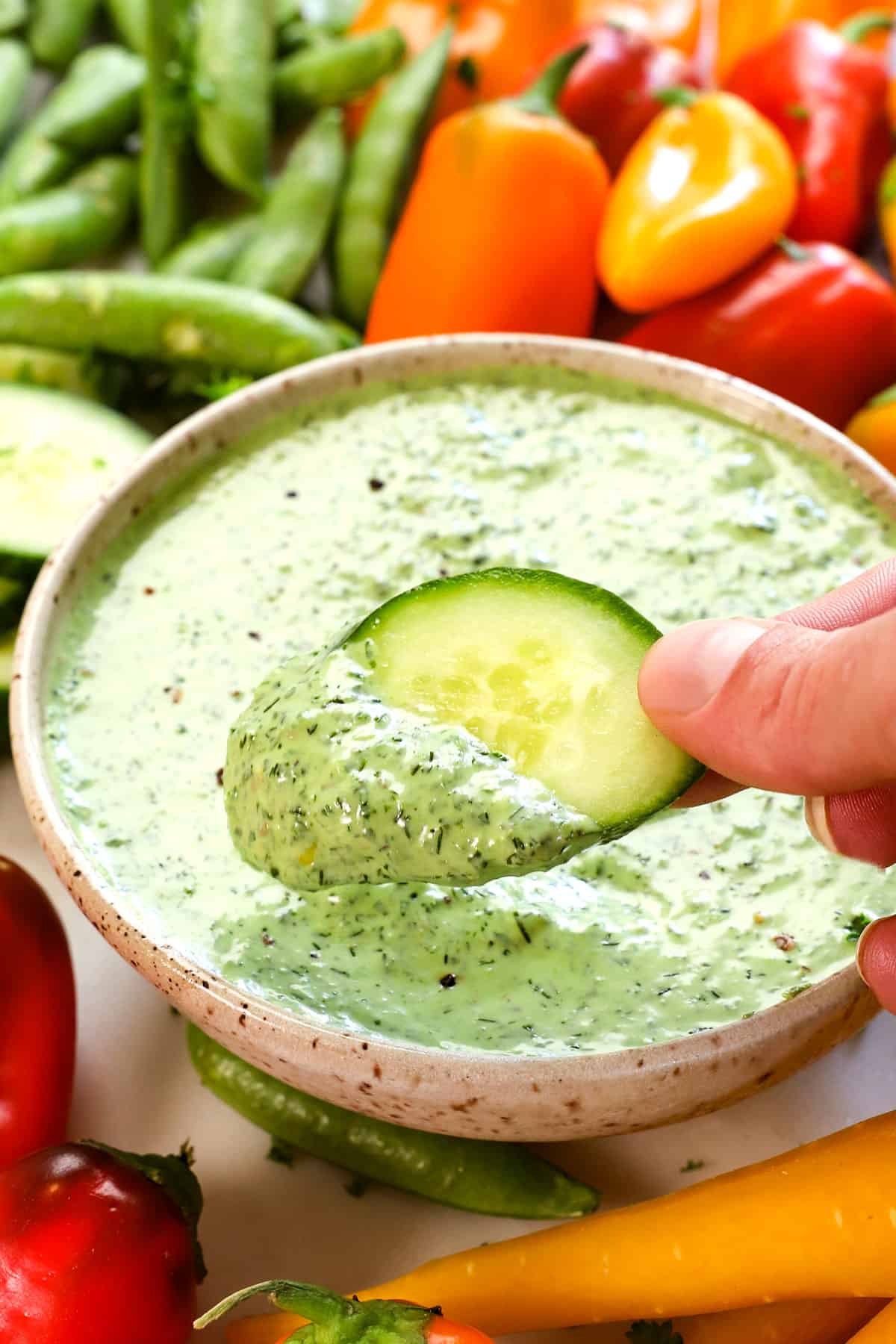 showing how to use green goddess dressing by dipping vegetables in it