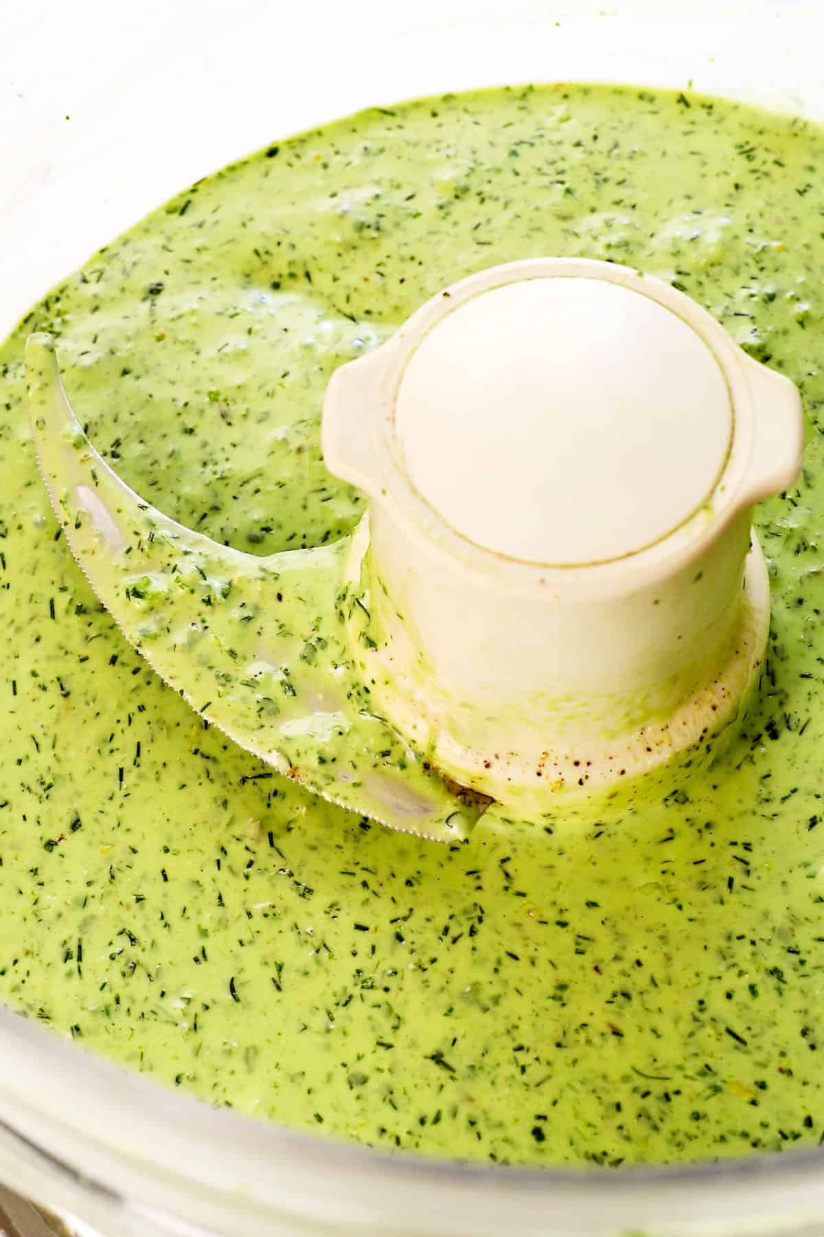 showing how to make green goddess dressing by processing the dressing until smooth