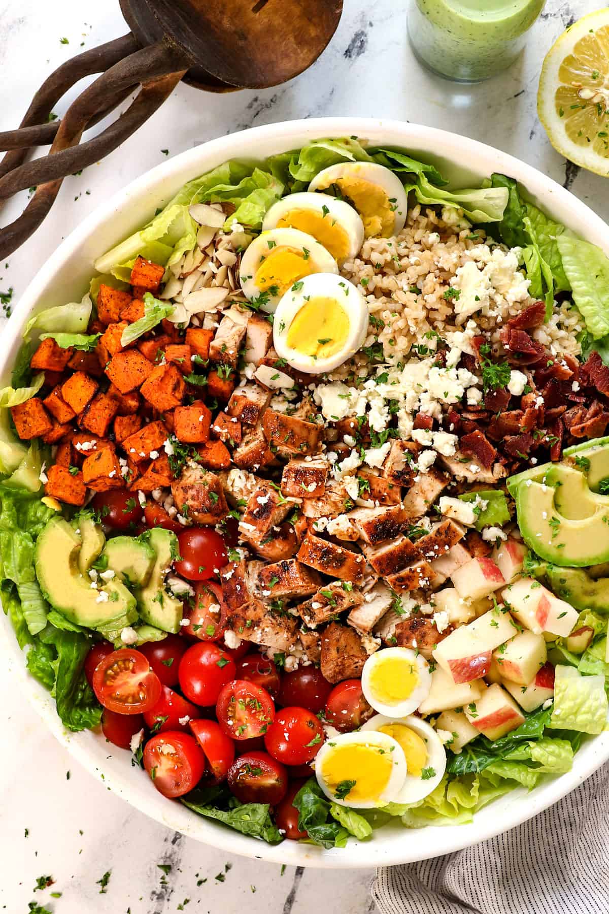 showing how to make green goddess salad by adding the ingredients to a bowl