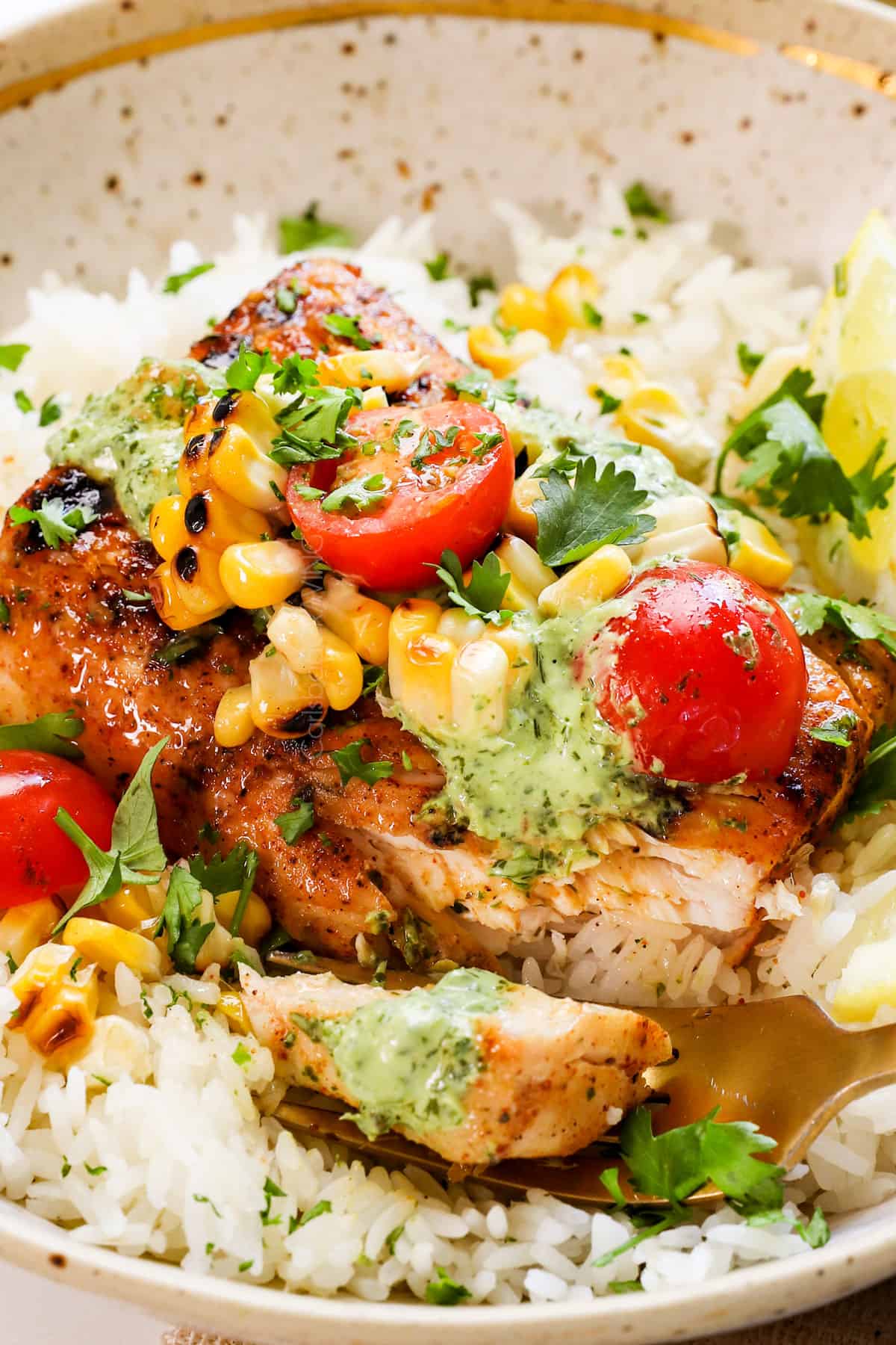 showing how to serve grilled mahi mahi recipe in a bowl with rice, topped with corn, and tomatoes