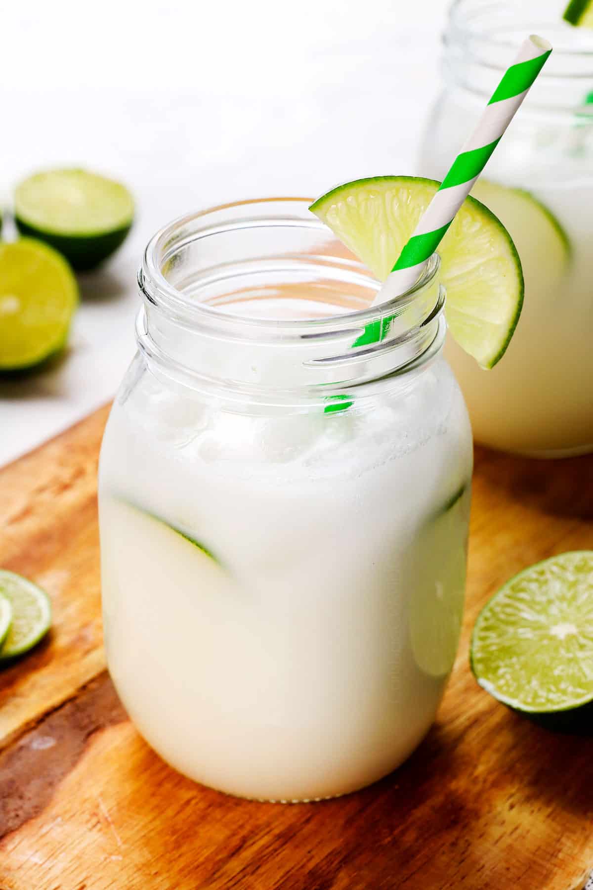 showing how to serve Brazilian limeade in a glass with eyes, garnished with lime slices