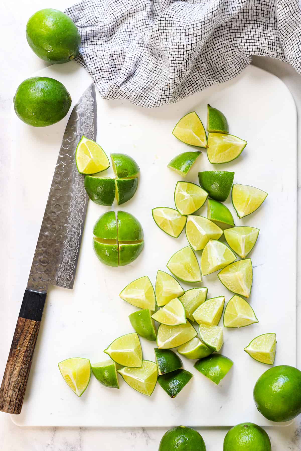 showing how to make Brazilian Lemonade by trimming the ends off of limes and slicing them in quarters