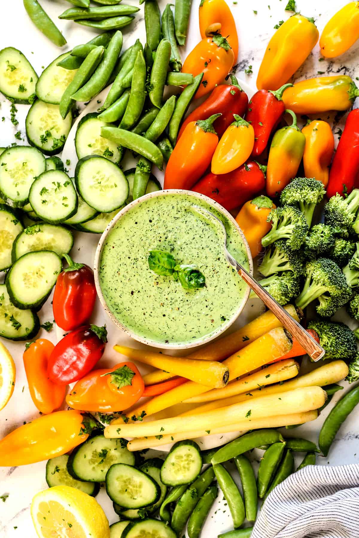 showing how to serve green goddess dressing as a dip in a bowl surrounded by vegetables