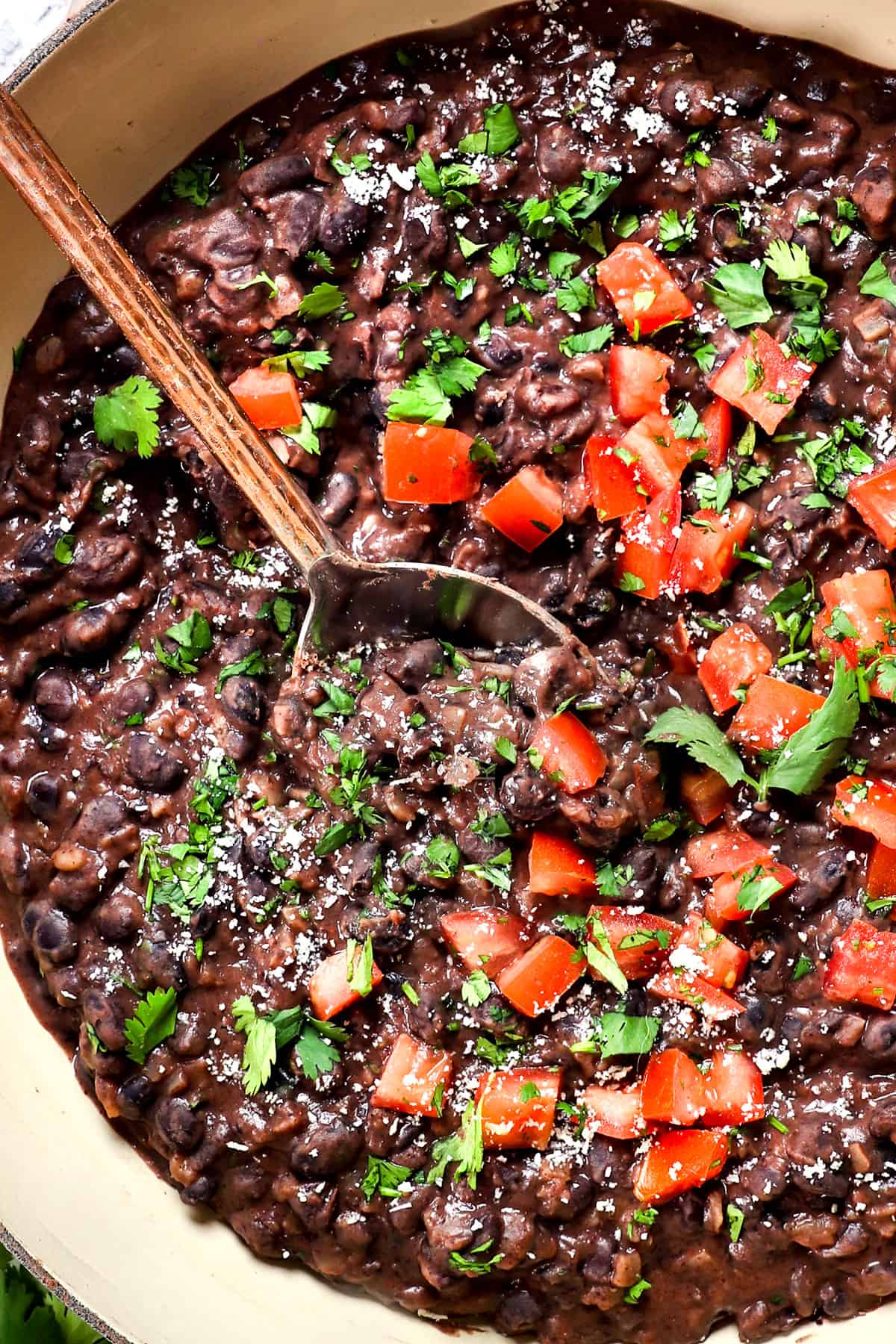 showing how to cook black beans by stirring in lime juice and cilantro 