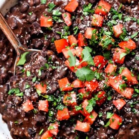 showing how to cook black beans by stirring in lime juice and cilantro