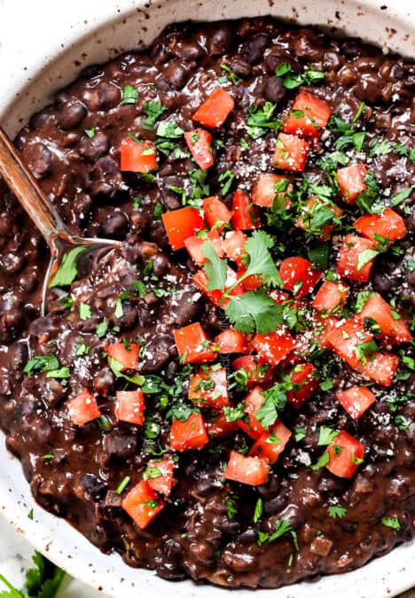 showing how to cook black beans by stirring in lime juice and cilantro