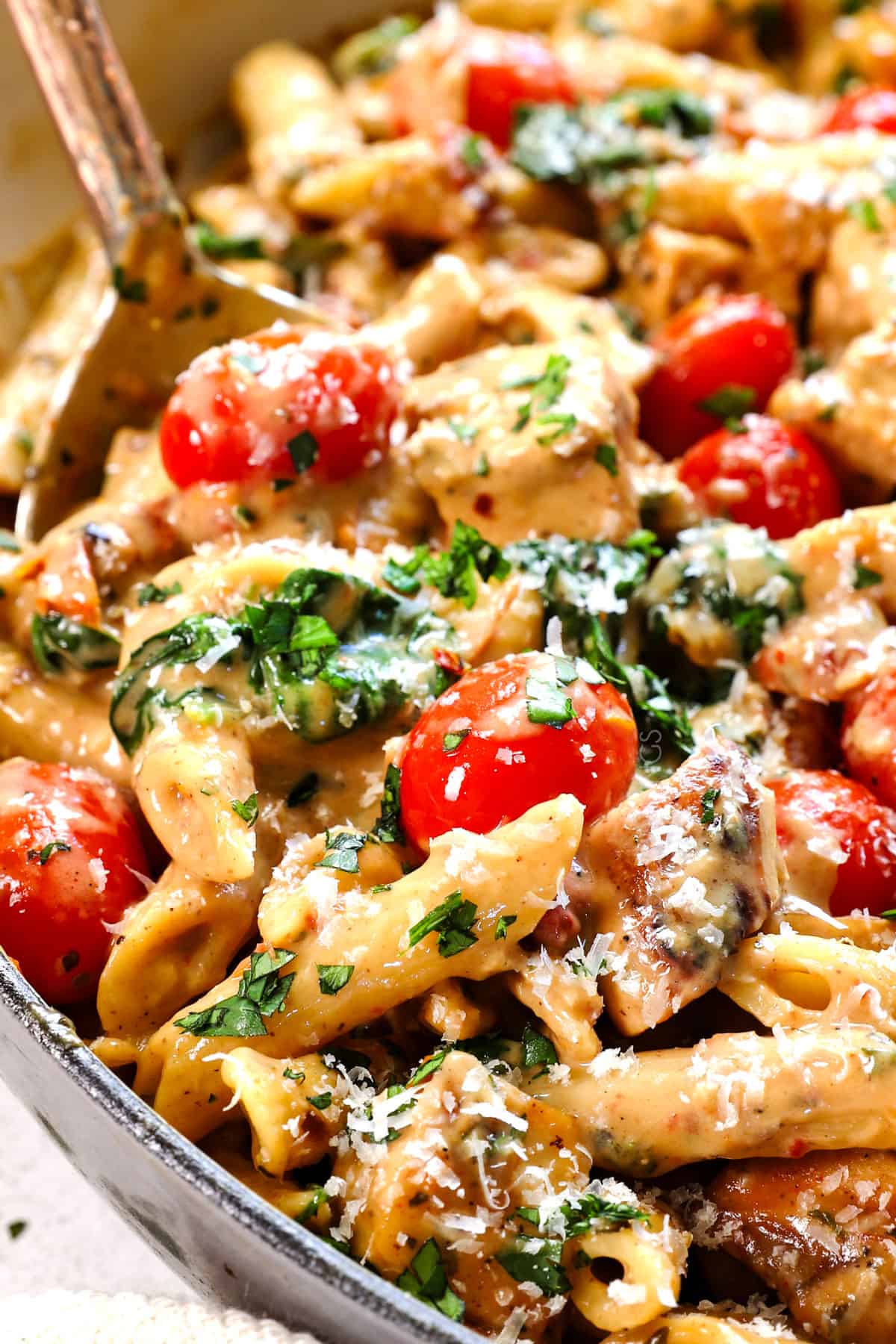 up close of serving chicken Tuscan pasta showing how creamy it is