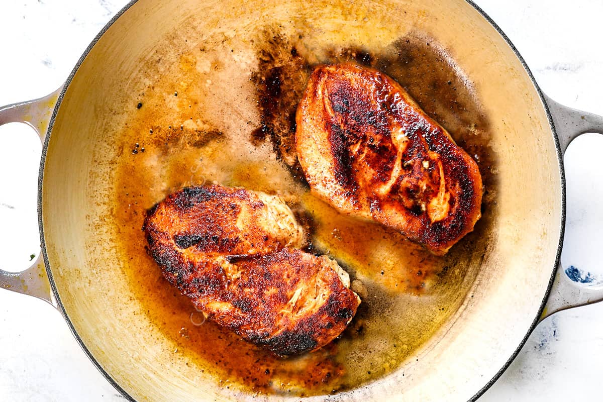 showing how to make Tuscan Chicken Pasta by searing the chicken in a skillet