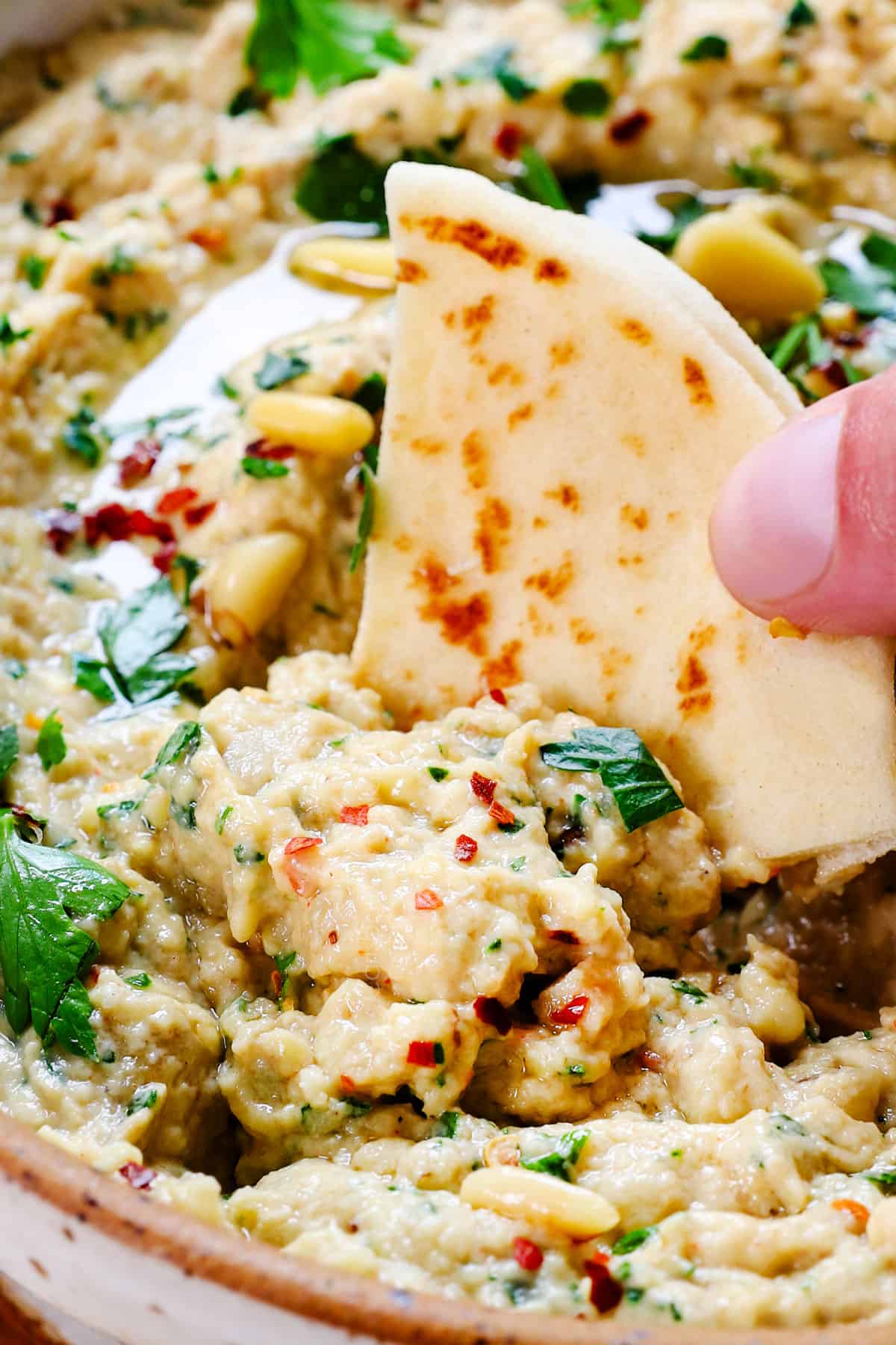 dipping into baba ganoush with pita bread 