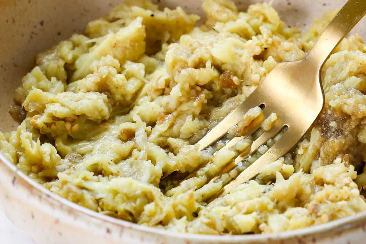 showing how to make baba ganoush by mashing the eggplant flesh with a fork