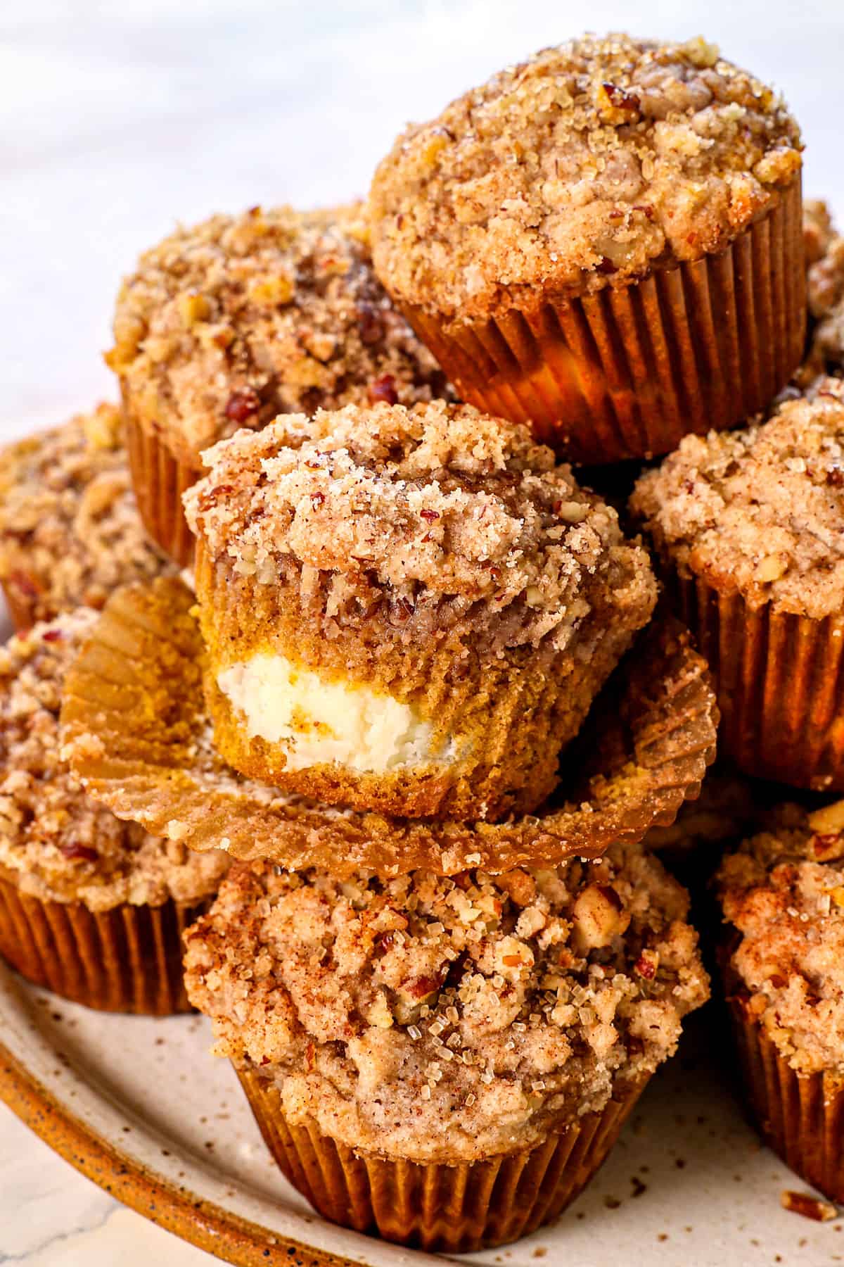 pumpkin muffins with cream cheese filling unwrapped showing the cheesecake filling