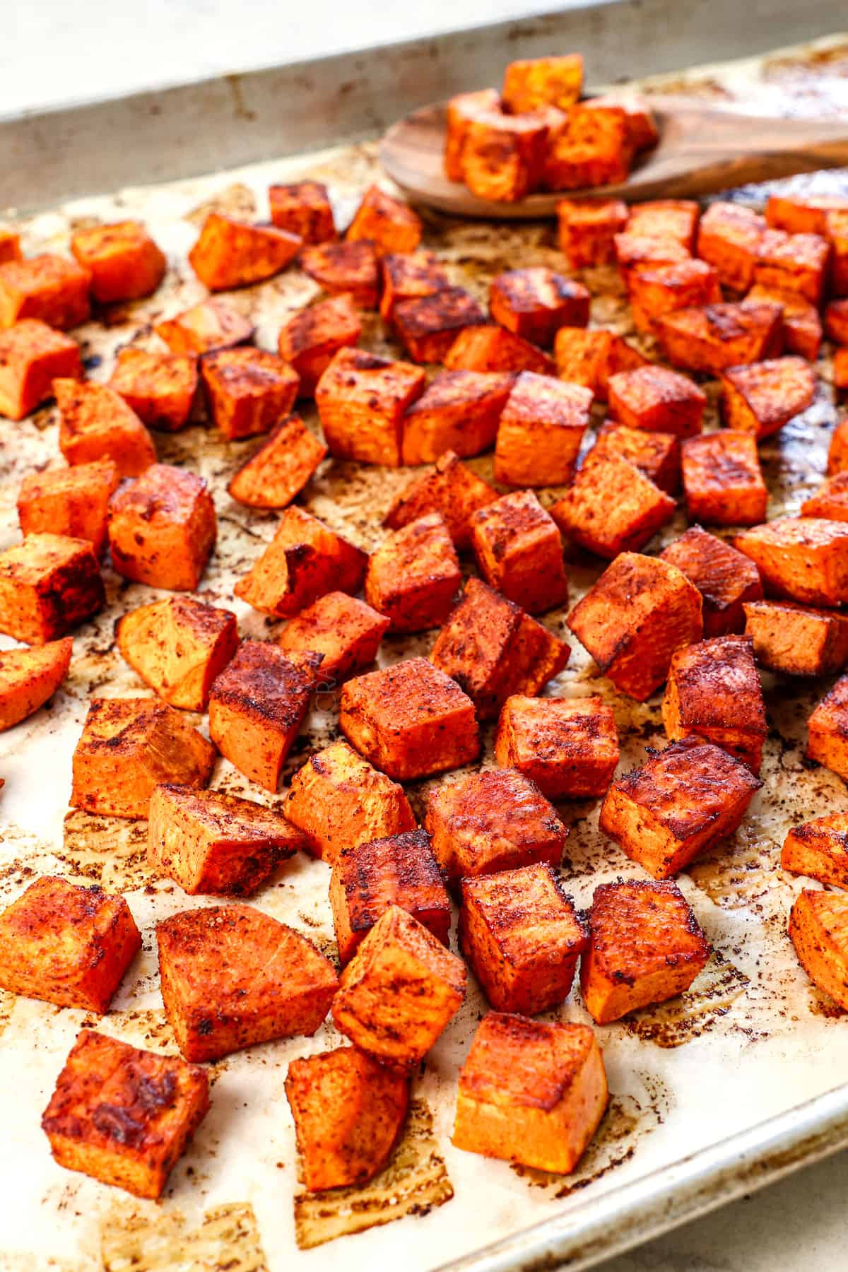 roasted sweet potato cubes on a baking sheet showing how caramelized they are