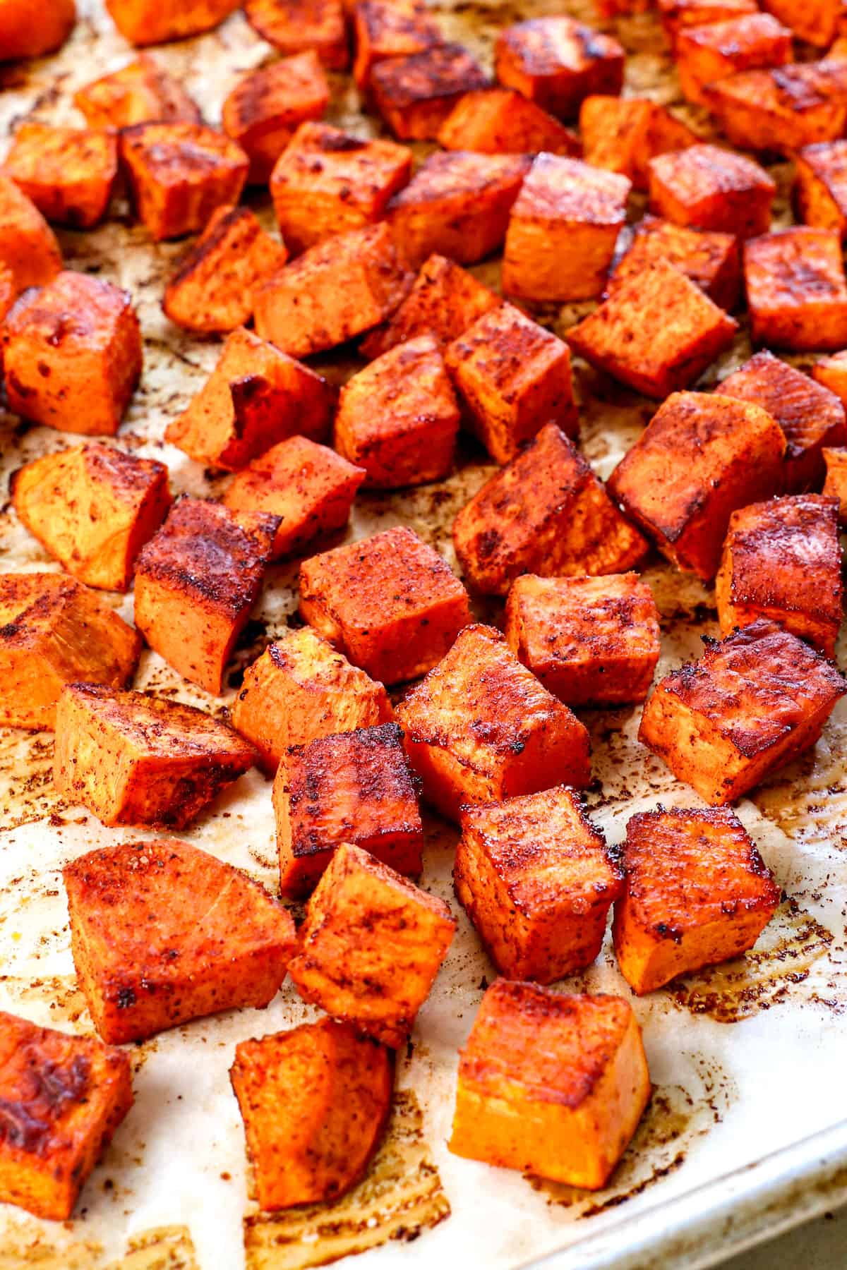 roasted sweet potato cubes on a baking sheet showing how caramelized they are