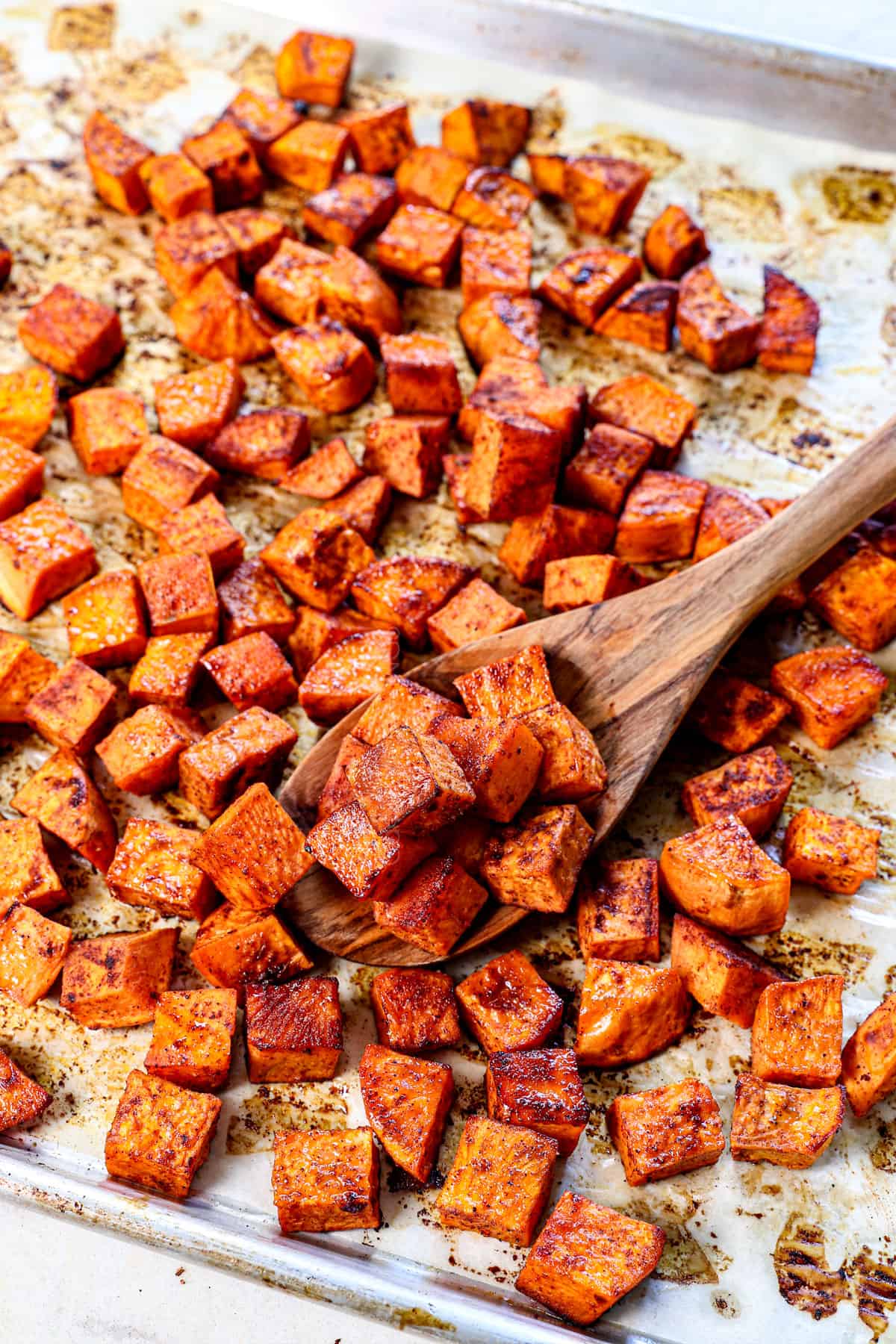 roasted sweet potato cubes on a baking sheet showing how caramelized they are