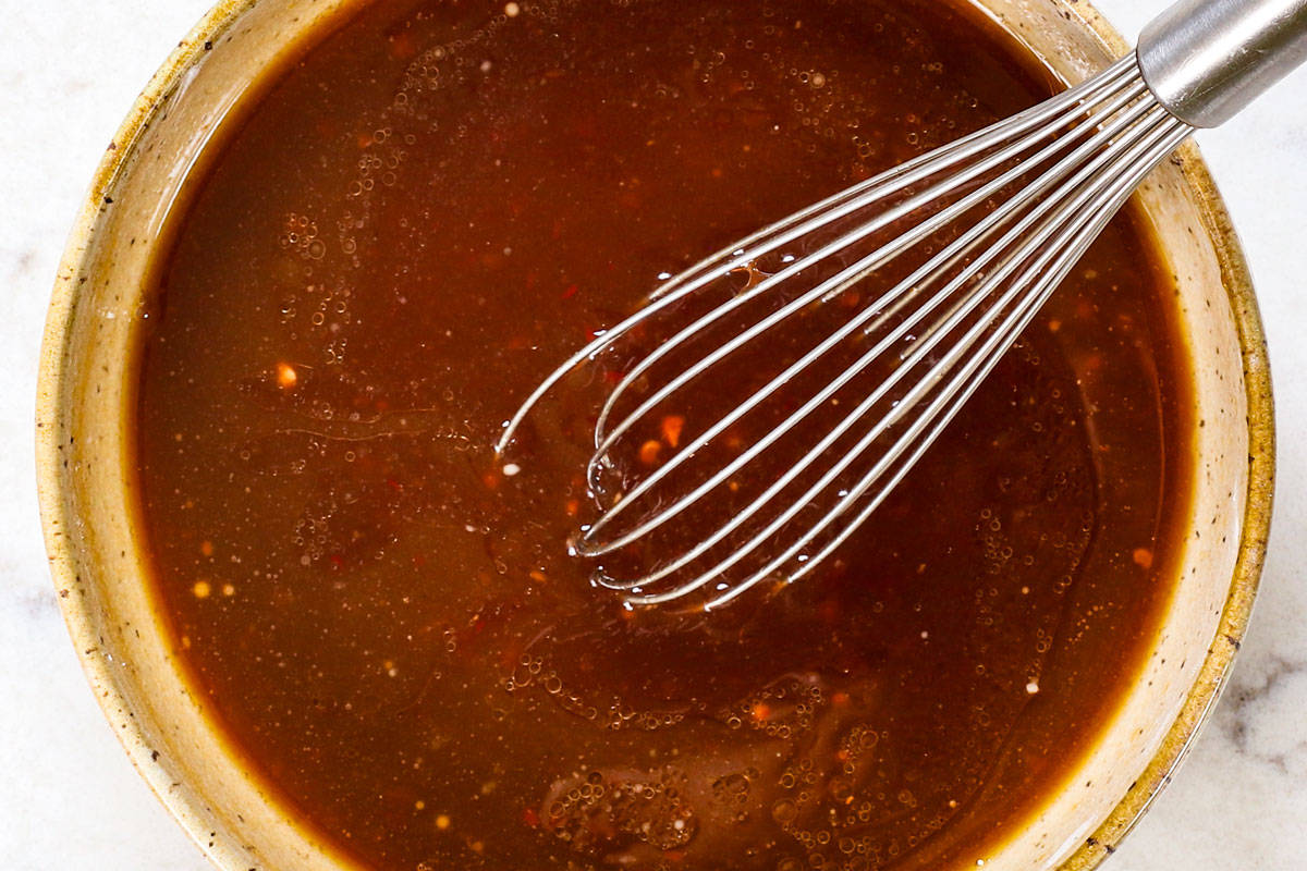 showing how to make Beijing Beef by whisking the sauce together