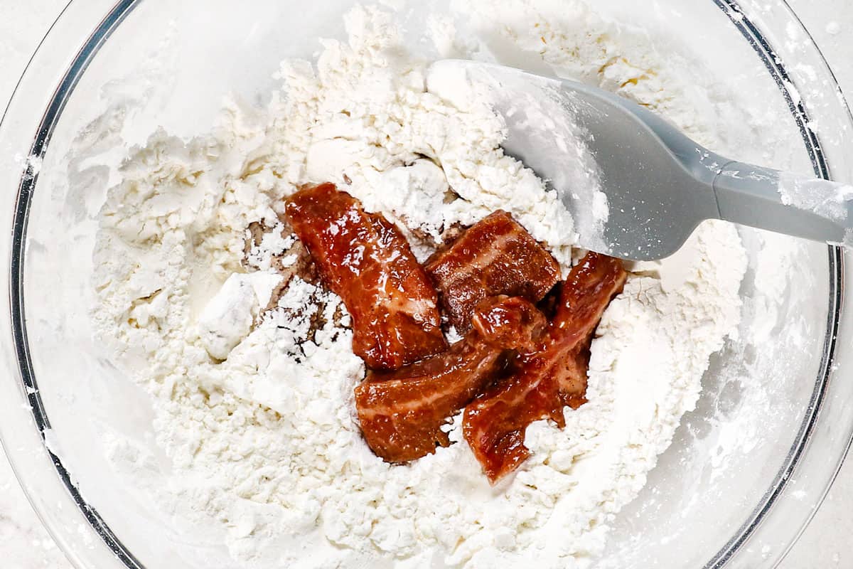 showing how to make Beijing Beef by dredging the beef in flour and cornstarch 