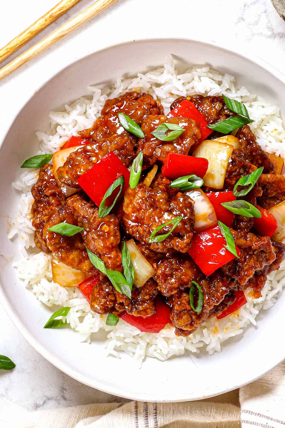 a bowl of Beijing beef recipe being served with rice