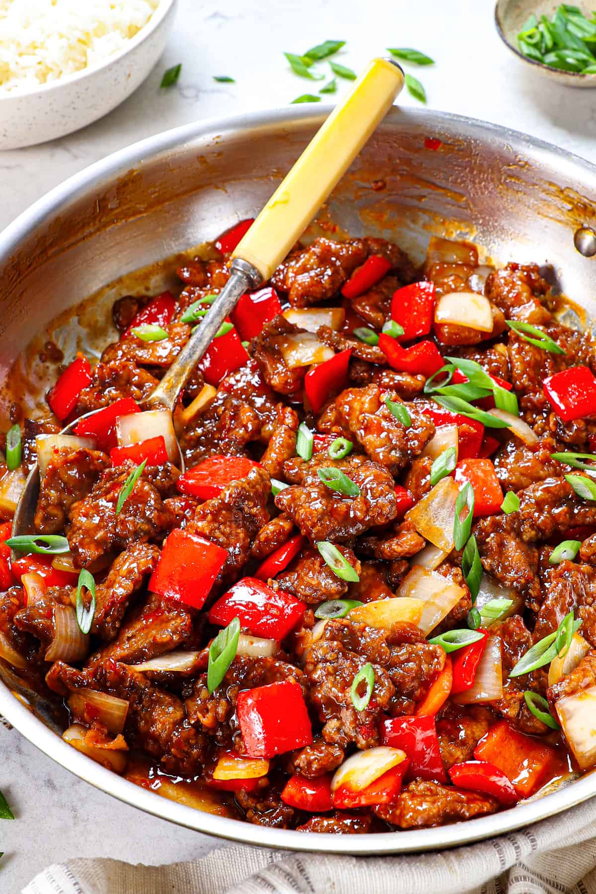 showing how to make Beijing Beef by garnishing with green onions 