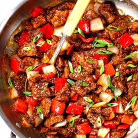 top view of Beijing beef panda express recipe garnished by green onions in a skillet