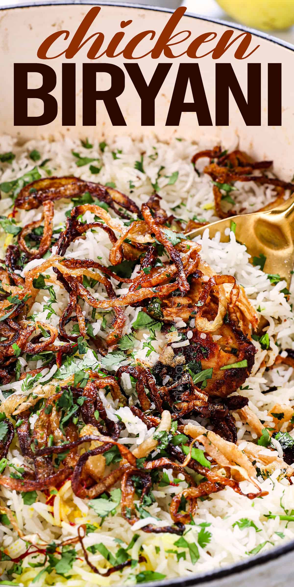 spooning biryani showing the rice, chicken and fried onions 