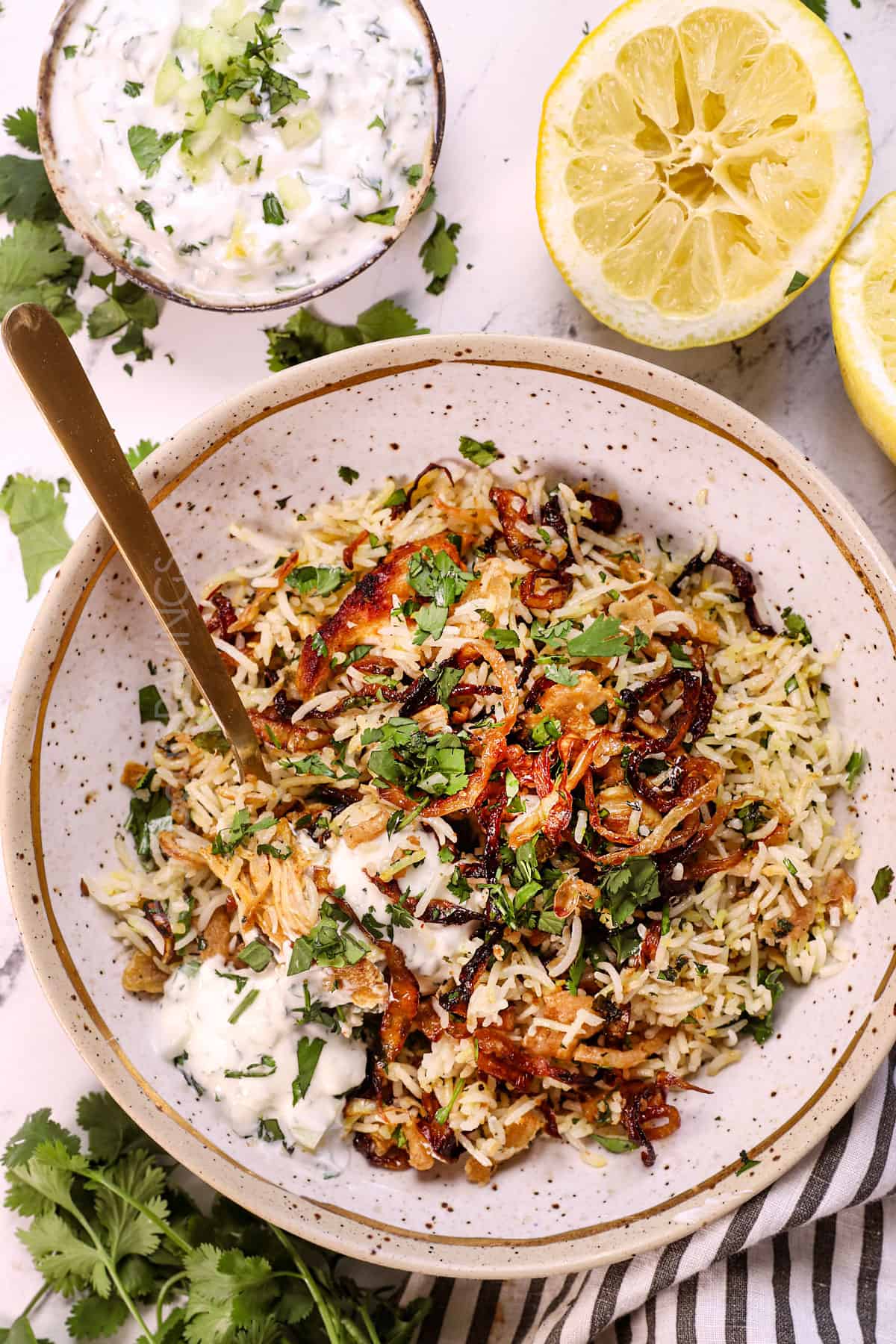 showing how to serve chicken biryani by adding it to a plate with raita 