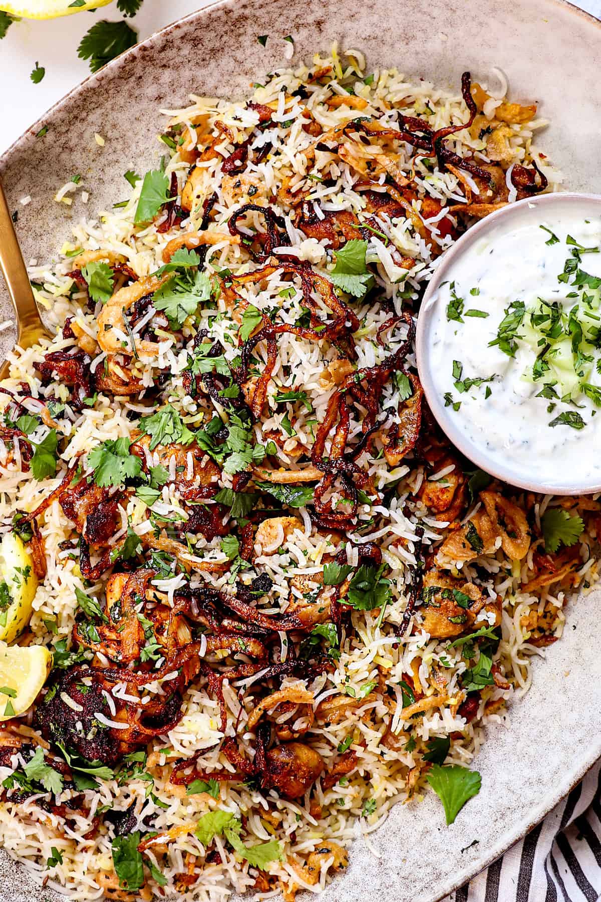 top view of serving biryani on a platter with raita 