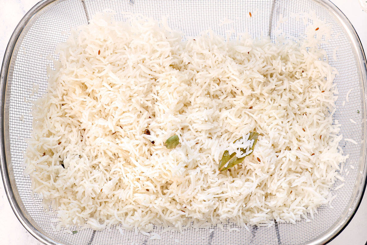 showing how to make biryani by par-cooking the rice with the whole spices, then draining