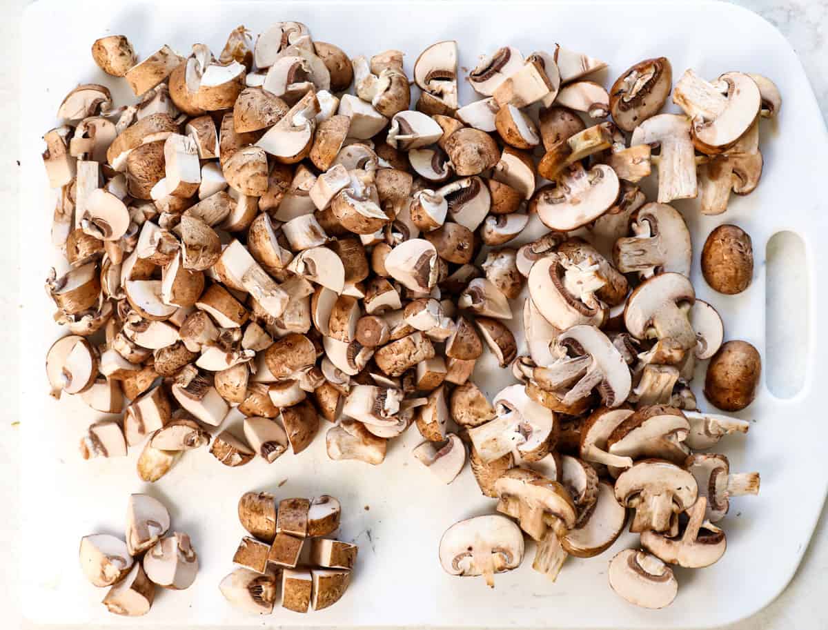 showing how to make mushroom soup by chopping some of the mushrooms and slicing the rest