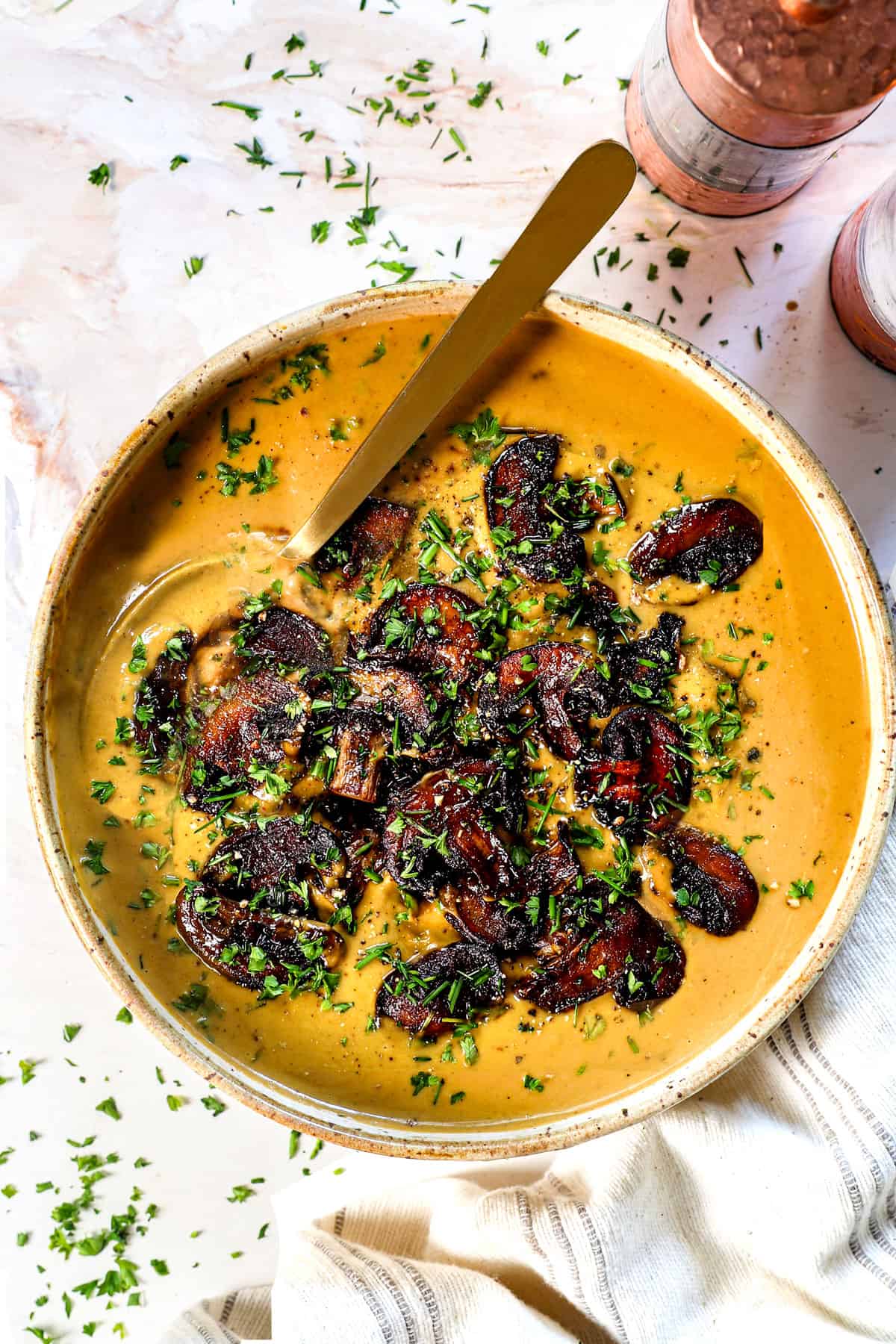 showing how to serve mushroom soup recipe in a bowl garnished with caramelized mushrooms