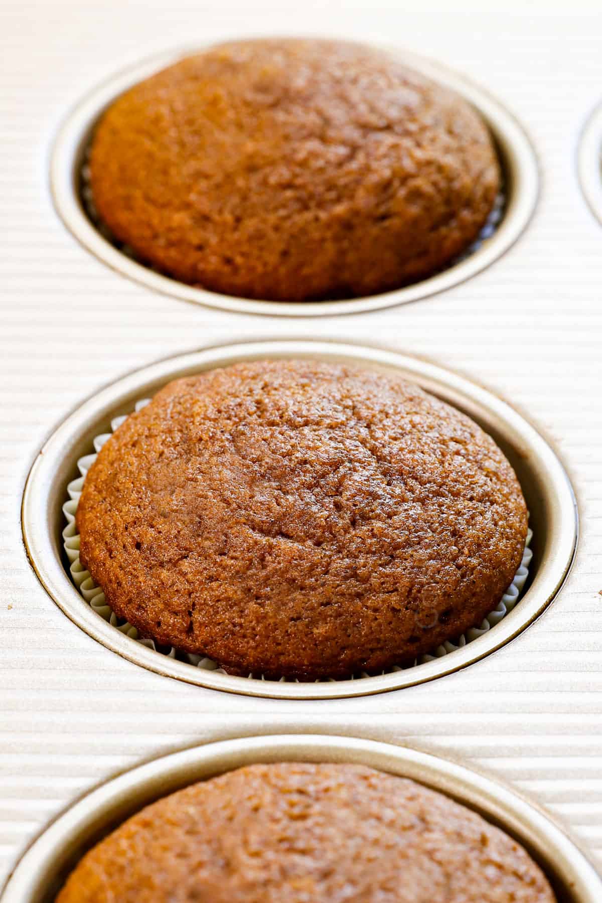 showing how to make pumpkin cupcakes by baking the cupcakes until a toothpick comes out clean