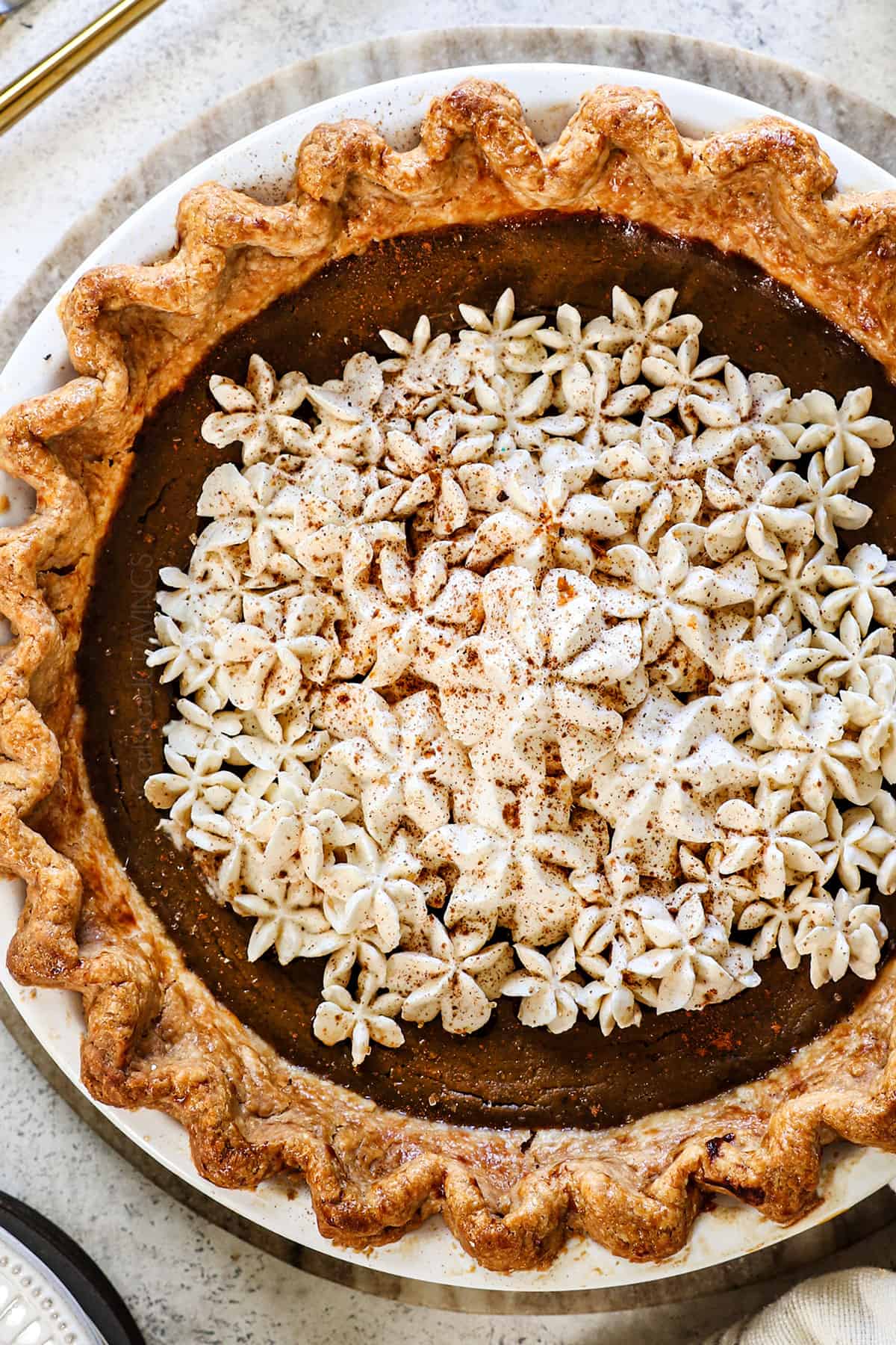 top view of pumpkin pie in homemade crust topped with whipped cream