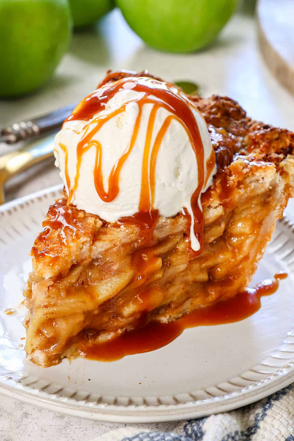 a slice of homemade apple pie recipe served on a plate drizzled with caramel sauce