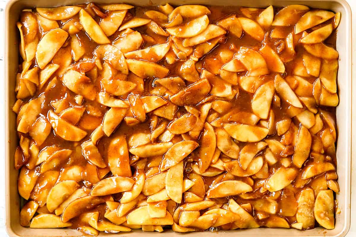 showing how to make apple pie recipe by cooling the cooked apple slices on a baking sheet