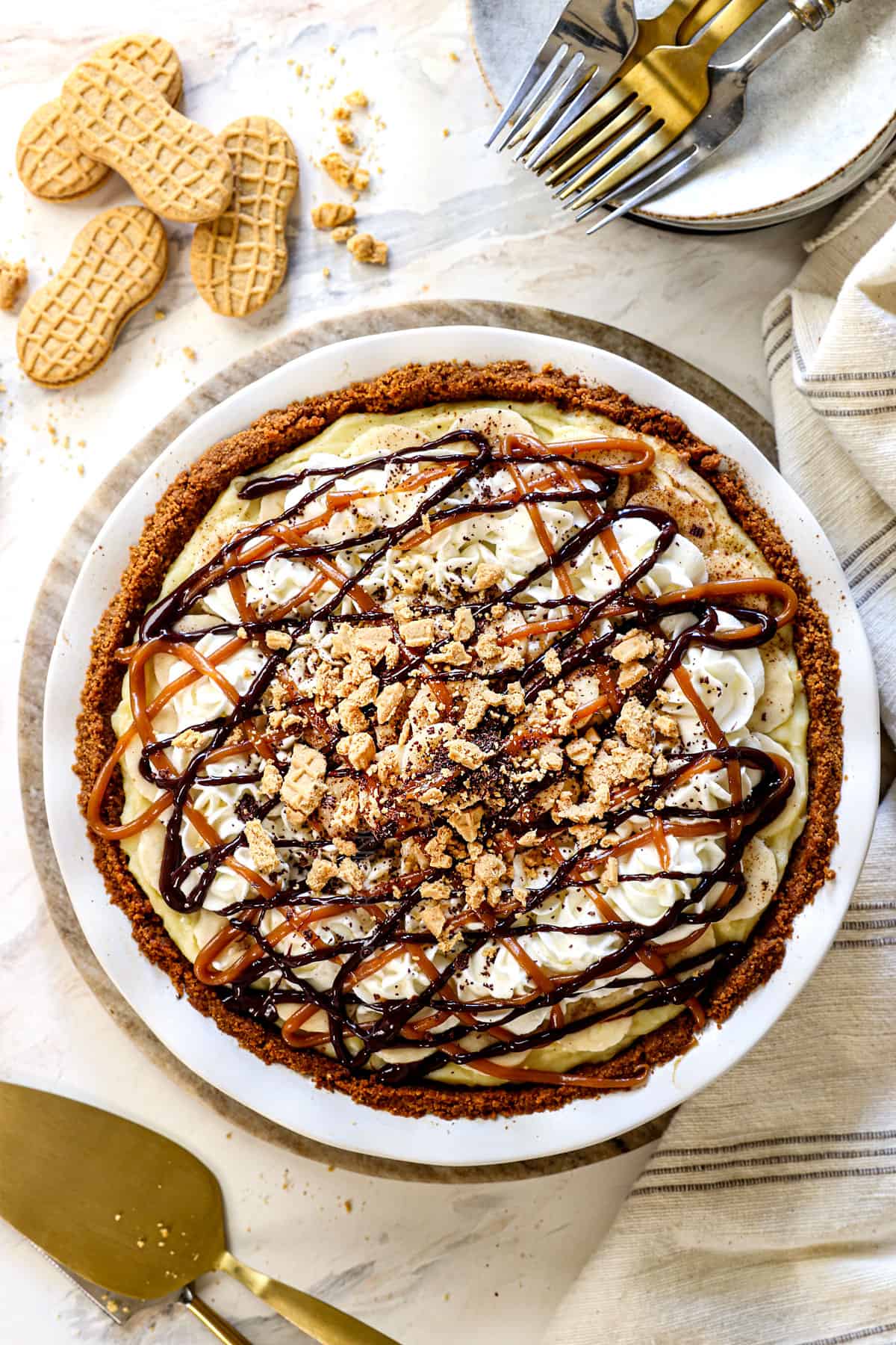 top view of homemade banana cream pie topped with whipped cream and bananas