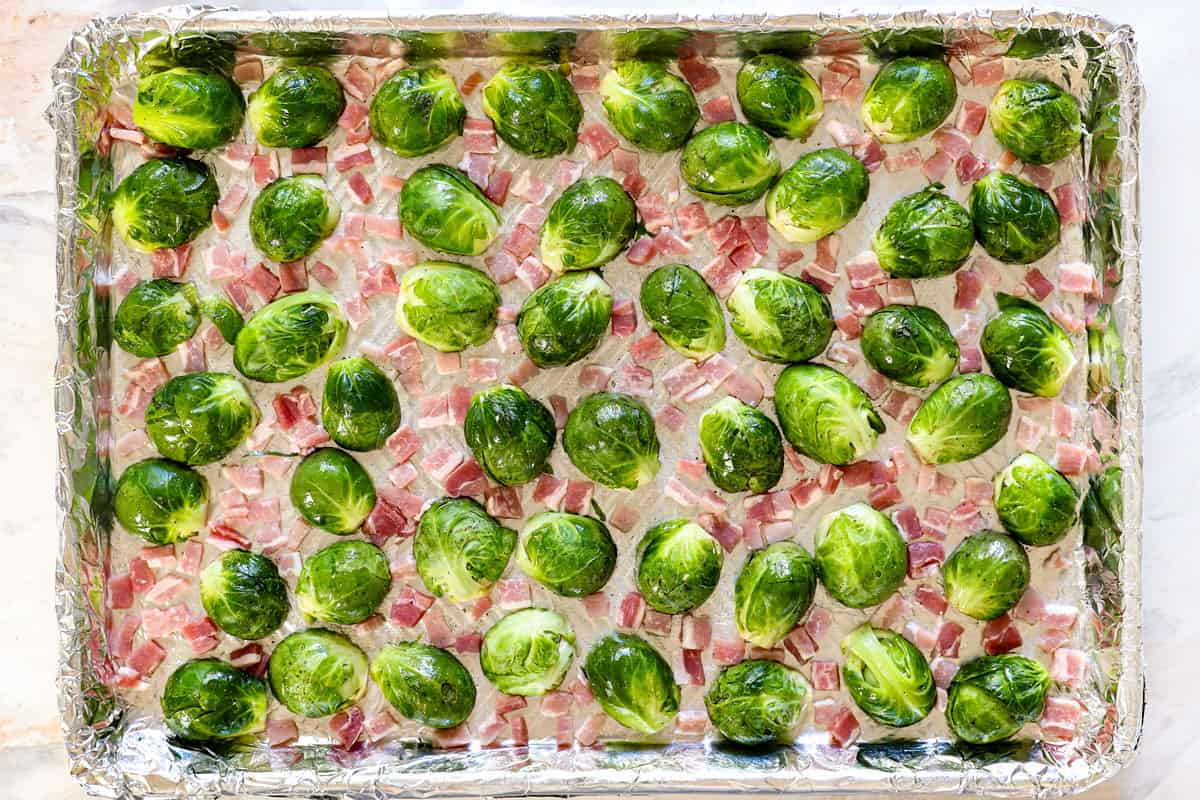 showing how to make Brussel sprouts with bacon by arranging them in a single layer on a baking sheet