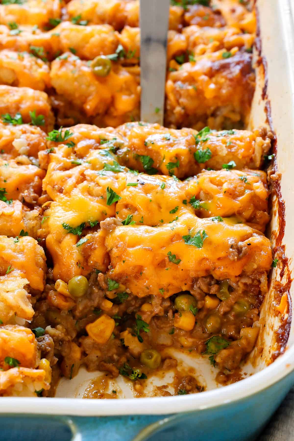 a scoop of recipe for tater tot casserole with ground beef and vegetables